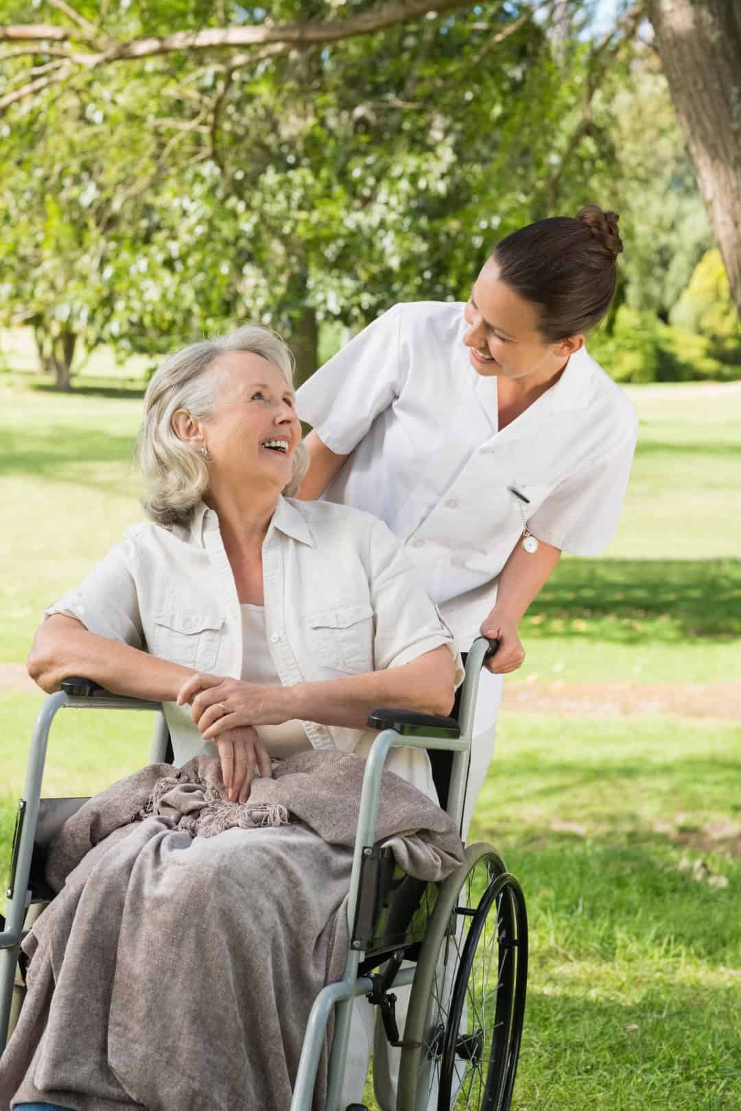 Happy older woman in wheelchair with support worker